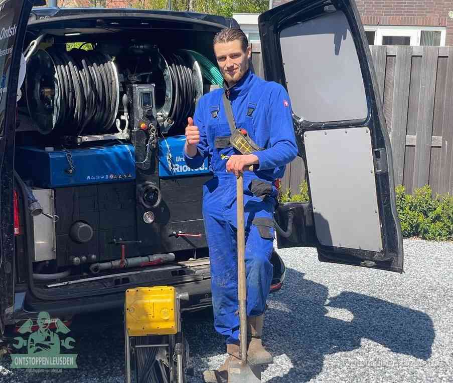 Een tevreden monteur met opgestoken duim naast de bestelbus, slim ingrijpen bespaart kosten bij een verstopte afvoer in Leusden