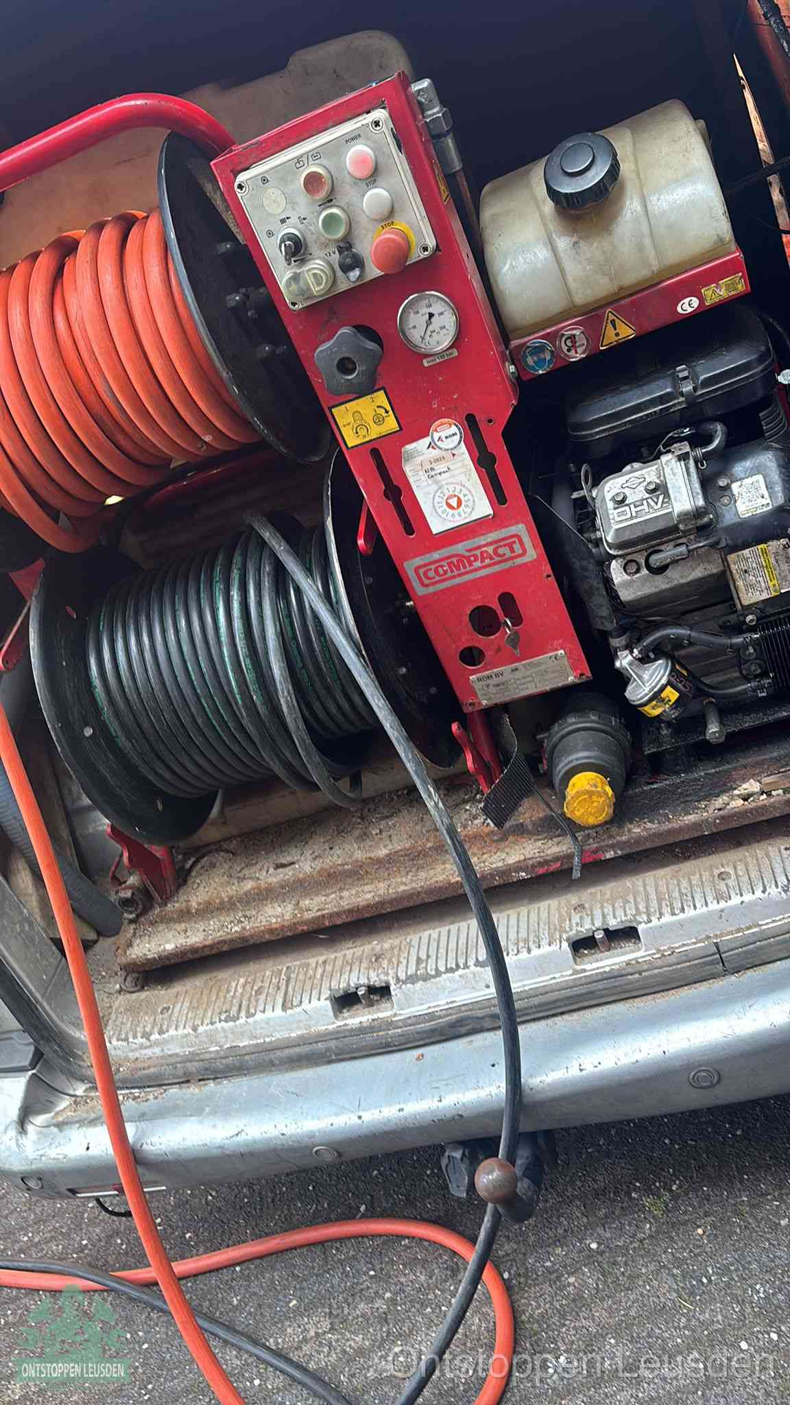 Een rood hogedruk-rioolreinigingstoestel in de laadbak van de bedrijfsbus, apparatuur voor een hardnekkige afvoerverstopping in Leusden
