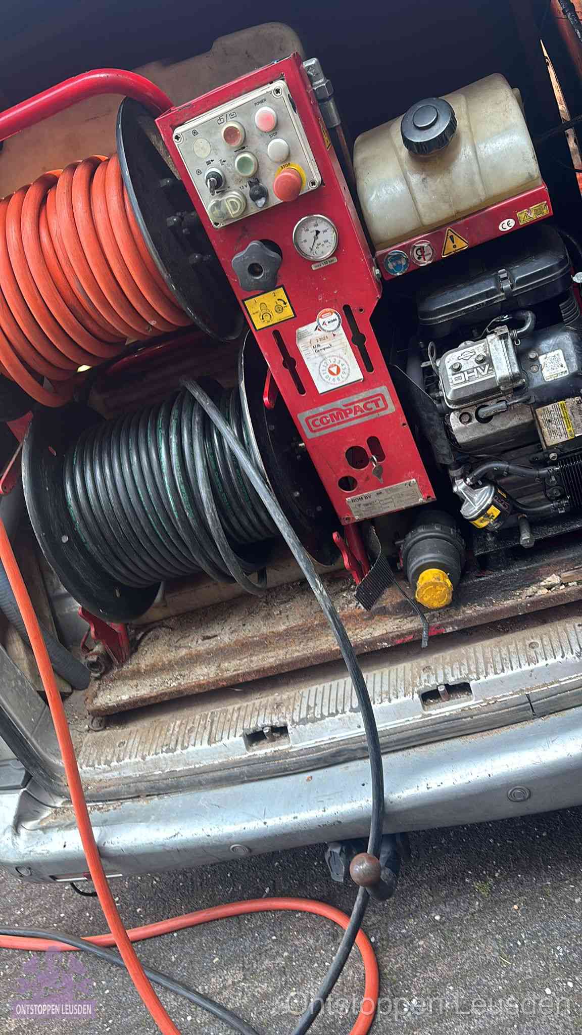 Een rood hogedruk-rioolreinigingstoestel met slangen in de laadbak van de bedrijfsbus, apparatuur voor een hardnekkige wc-verstopping in Leusden
