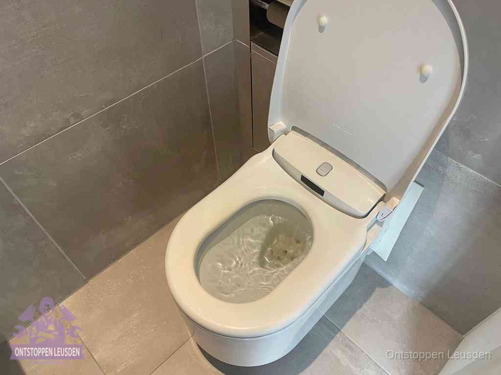 Een toiletpot vol troebel water met drijvend papier en restanten, de meest voorkomende oorzaak van een verstopte wc in Leusden