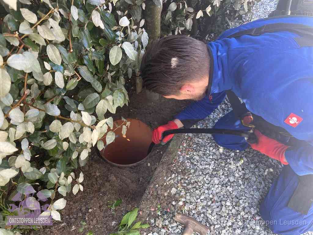 Monteur reinigt een rioolput met een slang, periodieke rioolreiniging in Leusden
