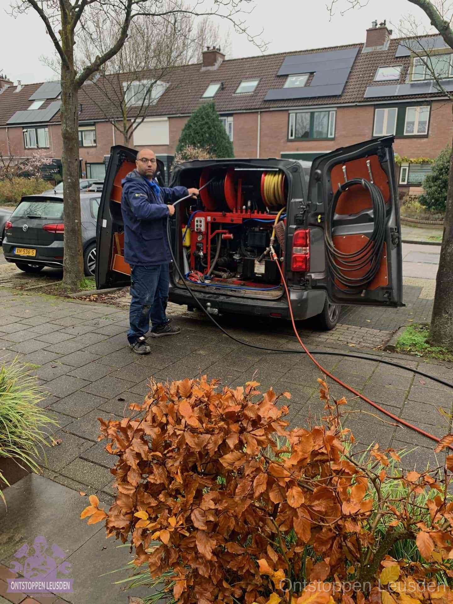 Monteur met rioolreinigingsbus levert rioolservice in de wijk in Leusden