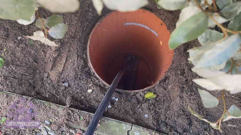 Open inspectieput in de tuin waar een veer rioolvliegjes en stankoverlast aanpakt in Leusden