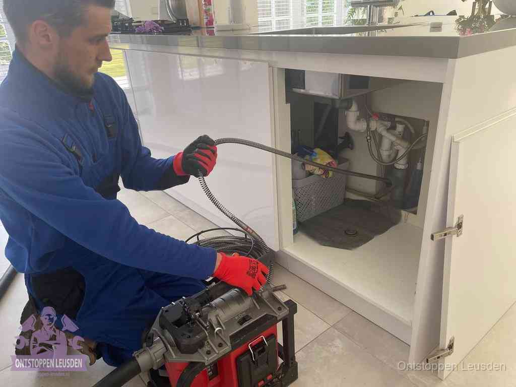 Een monteur reinigt de keukenafvoer grondig met een veermachine om terugkerende gootsteenverstoppingen te voorkomen in Leusden