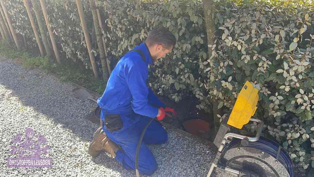 Monteur aan het werk bij een rioolput, de werkwijze voor riool ontstoppen in Leusden